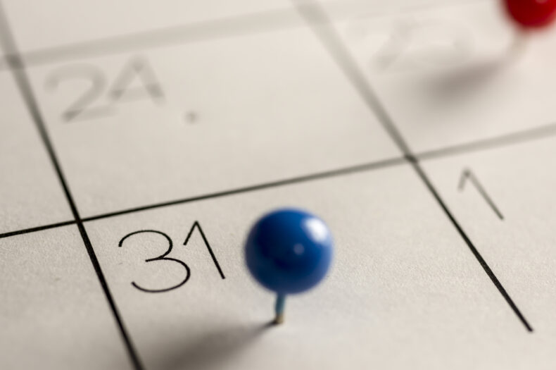 Close up shot of a calendar with a pin on the number 31 indicating a deadline